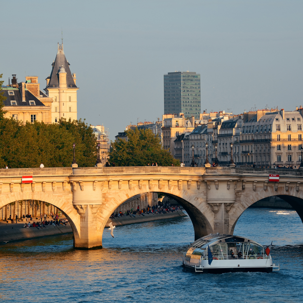 Desk with map, computer screen displaying map, coffee mug, succulent, and window view.