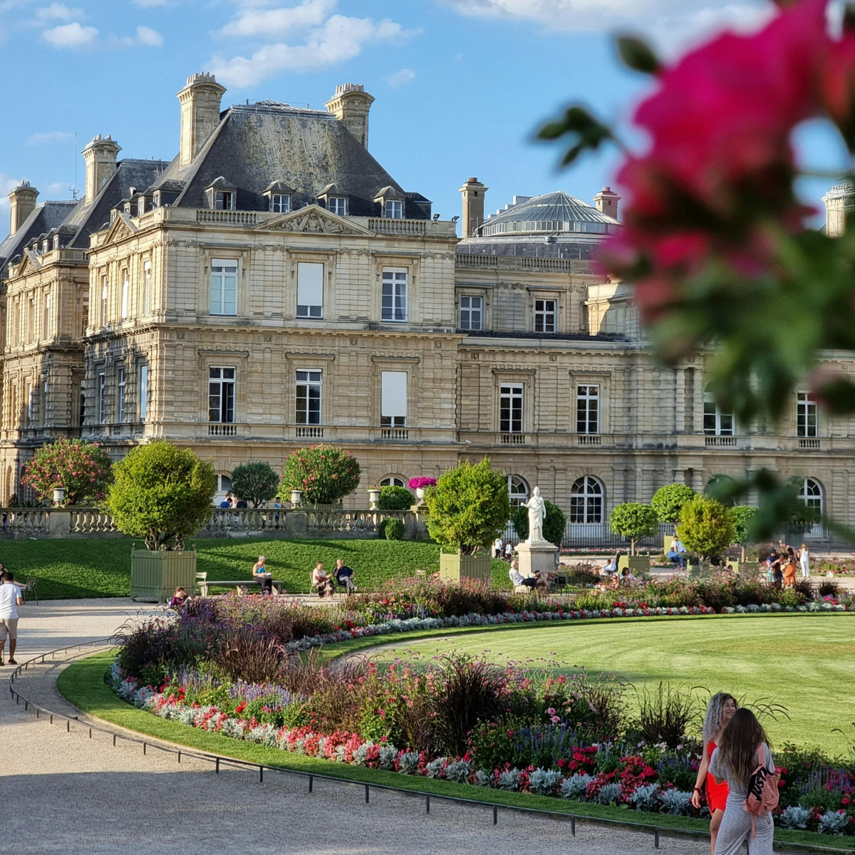 Woman wearing headset at desk with computer, Eiffel Tower art in background.