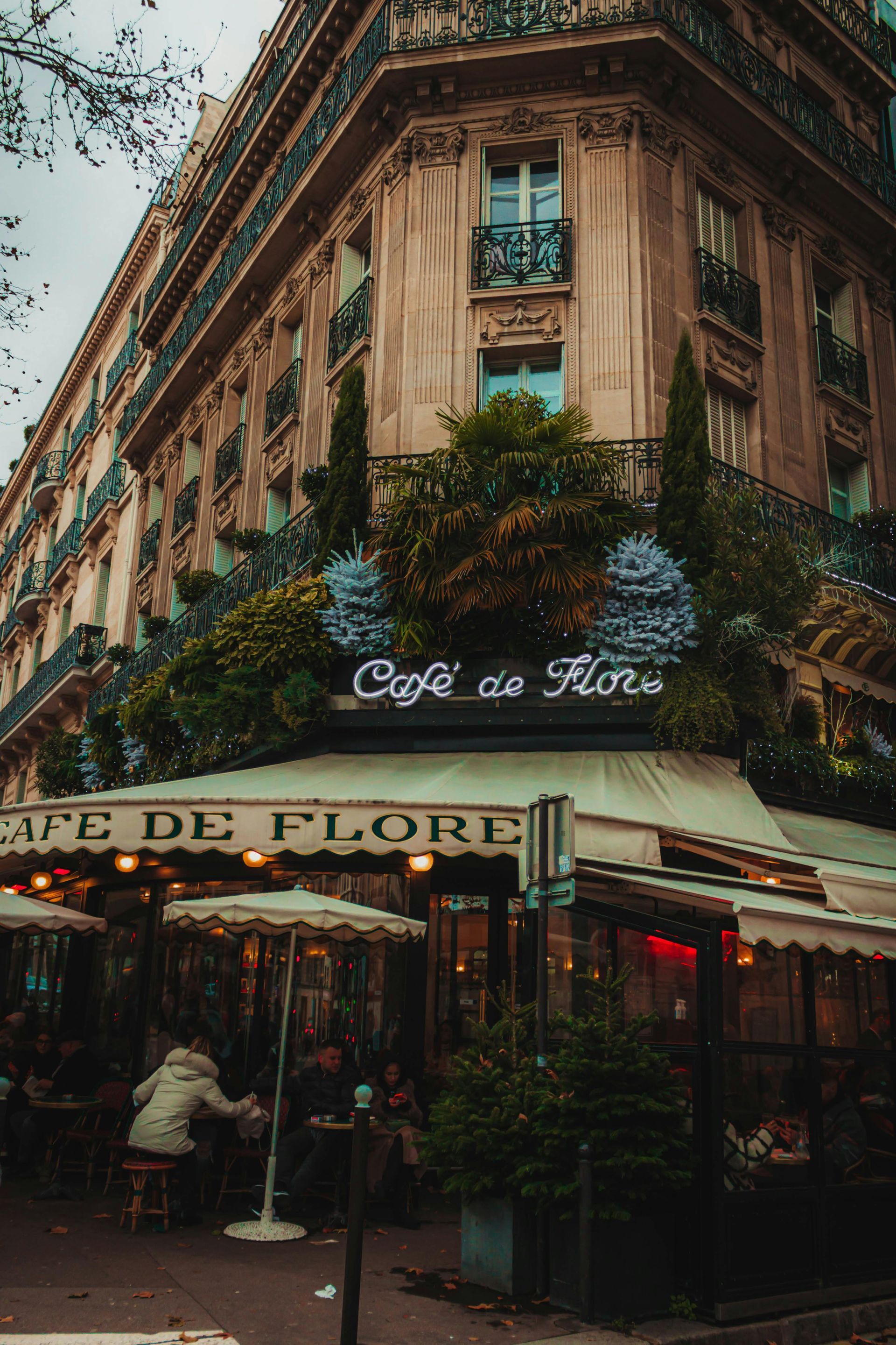 Café de Flore in Paris. Building corner, cafe with outdoor seating, awning, sign, and facade.
