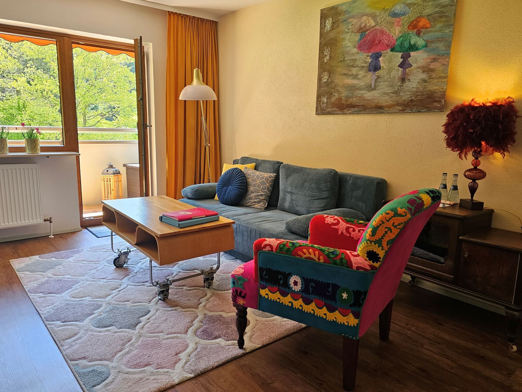 Gemütlicher Wohnbereich der Ferienwohnung Hirschlein mit Sofa, Sessel und Zugang zum Balkon im Schwarzwald