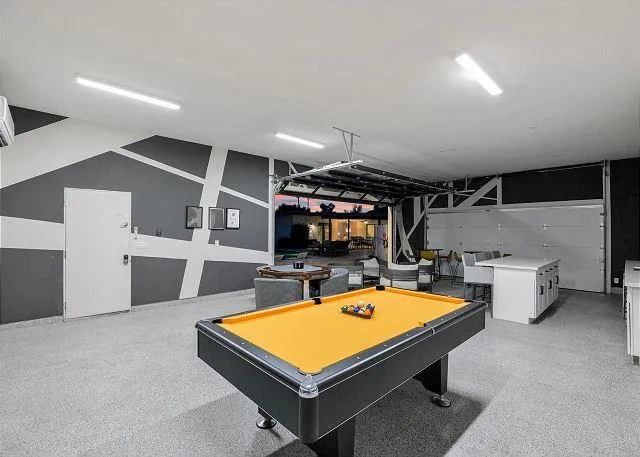 Game room with pool table and abstract wall design.