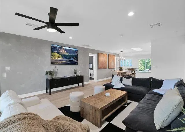 Living room with sectional sofa, coffee table, TV, and black and white rug.