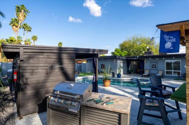 Backyard with grill, pool, seating, and a sign that says