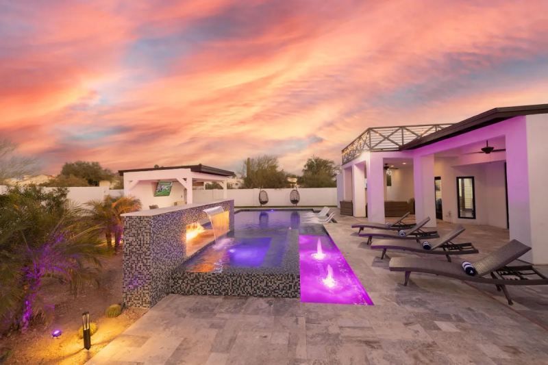 Poolside patio at sunset with vibrant pink and orange sky.