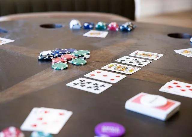 Poker table with playing cards and colorful chips.