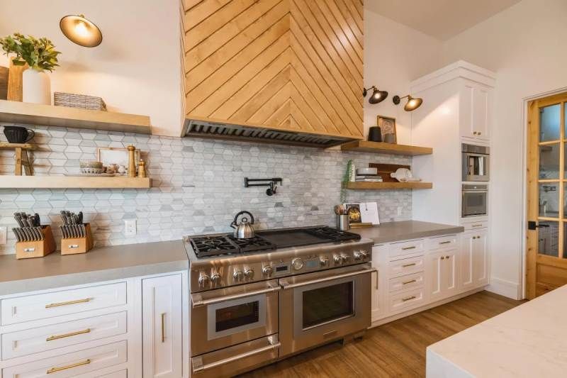 Stylish kitchen with stainless steel appliances, white cabinets, and wooden accents.