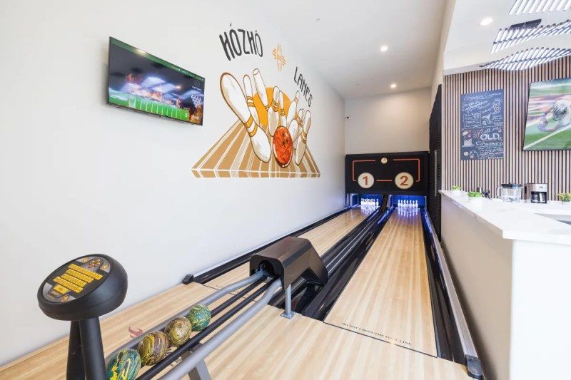 Bowling alley with lanes, bowling balls, and wall art.
