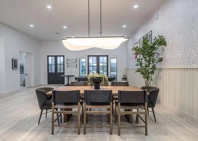 Dining room with wooden table, dark chairs, and a unique light fixture.