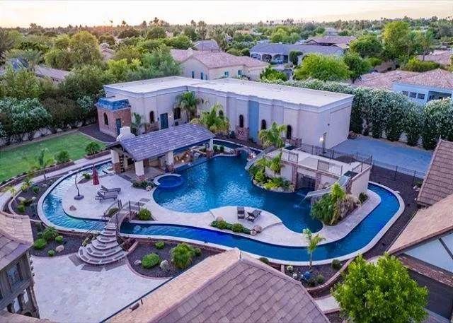 Luxury home with a large pool, swim-up bar, and lazy river.