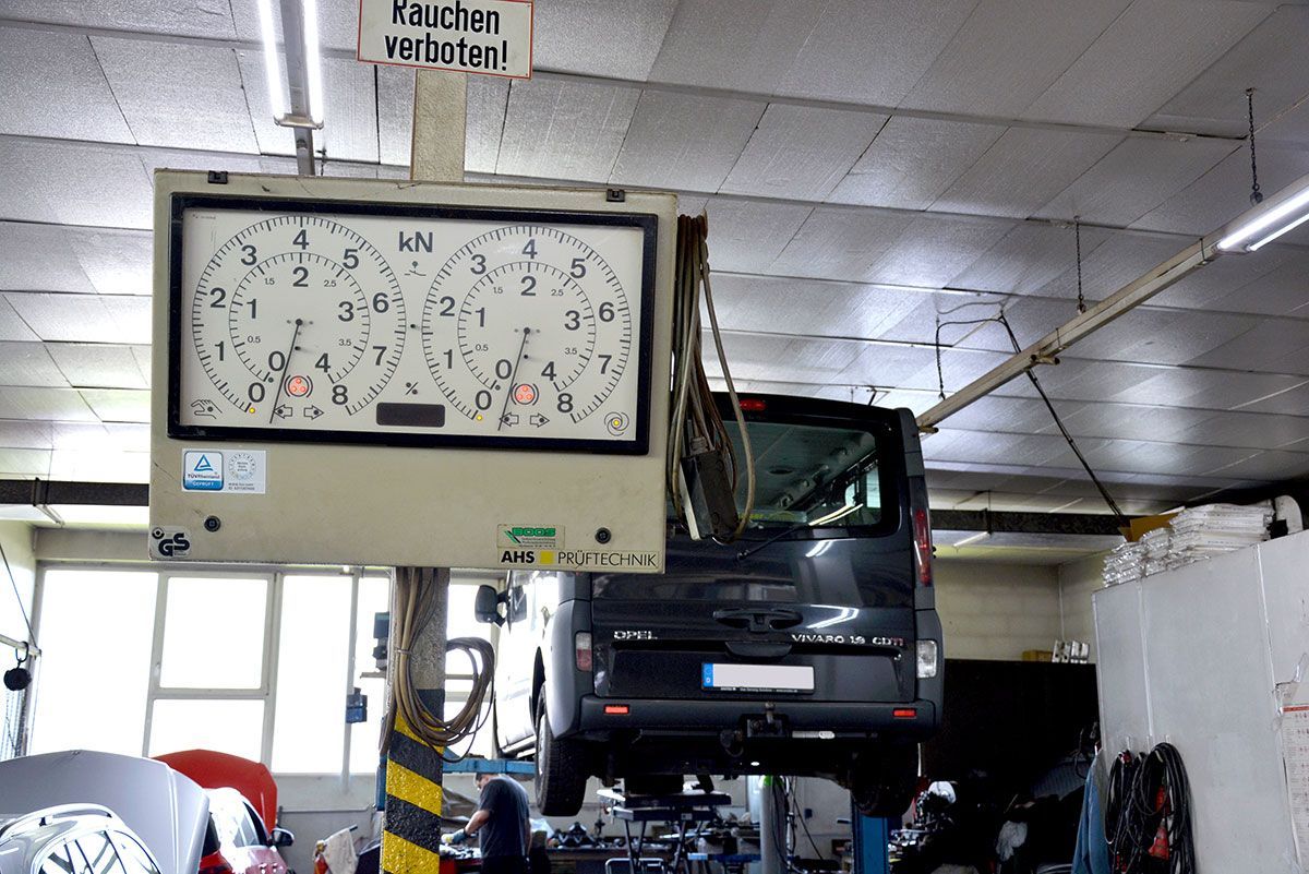 Eine Uhr, die in einer Garage von der Decke hängt, mit einem Schild mit der Aufschrift 