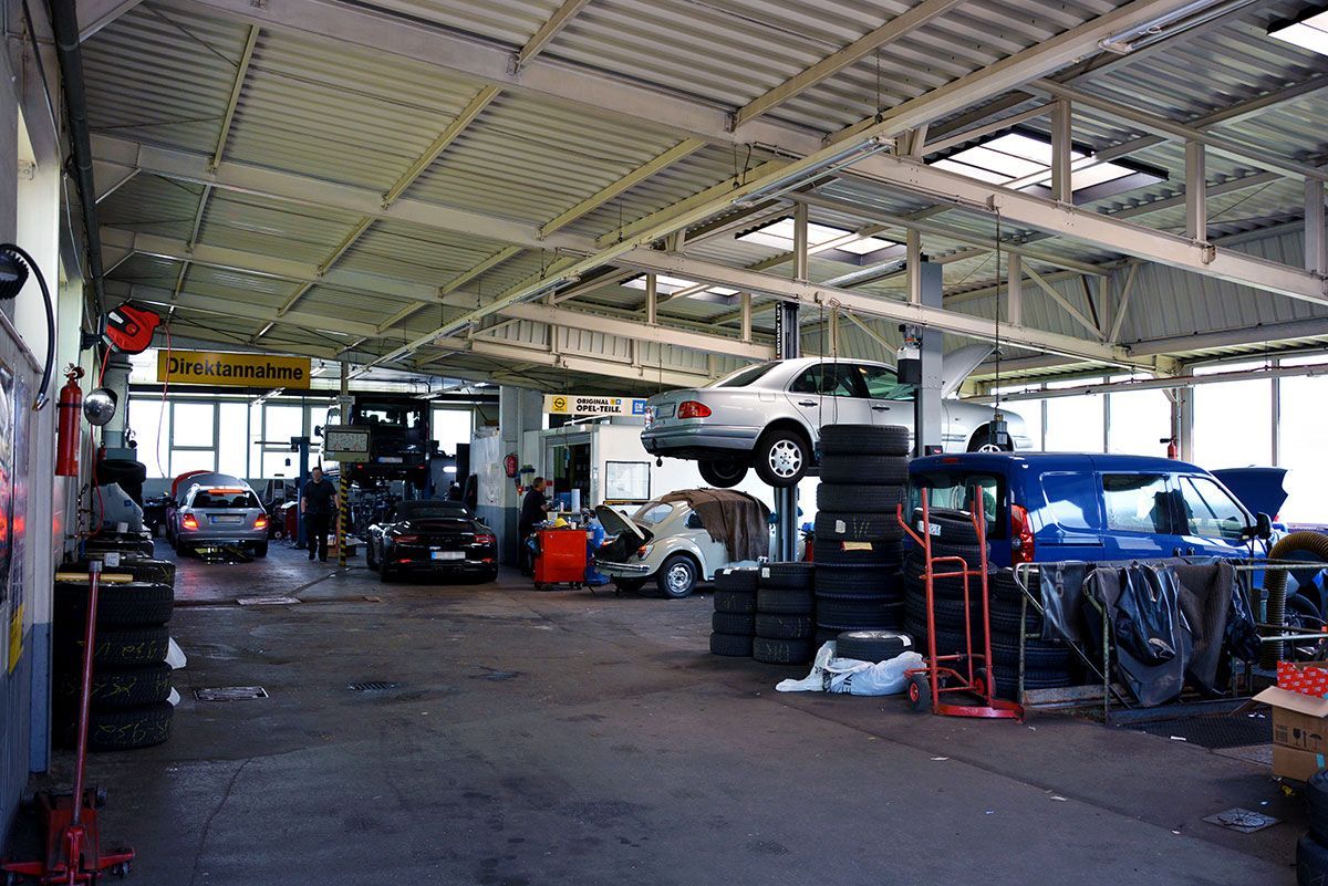 Ein Auto steht auf einem Reifenstapel in einer Garage