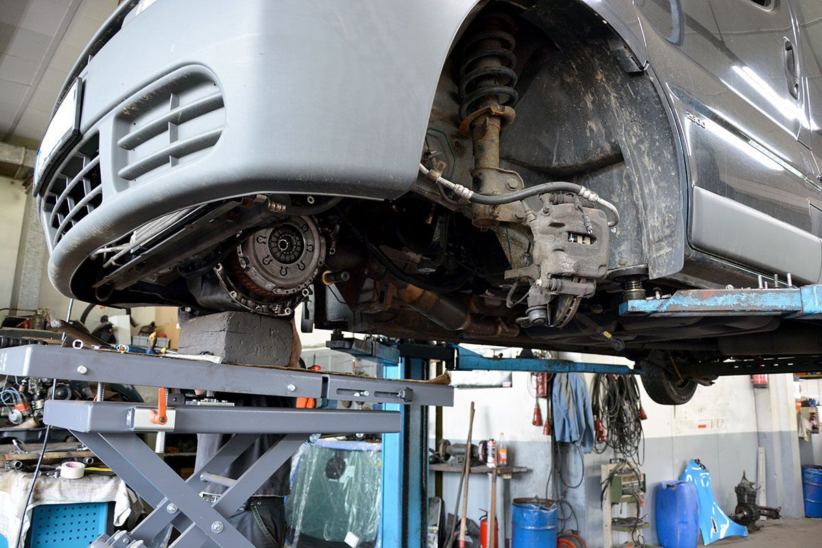 Ein Auto steht auf einer Hebebühne in einer Garage