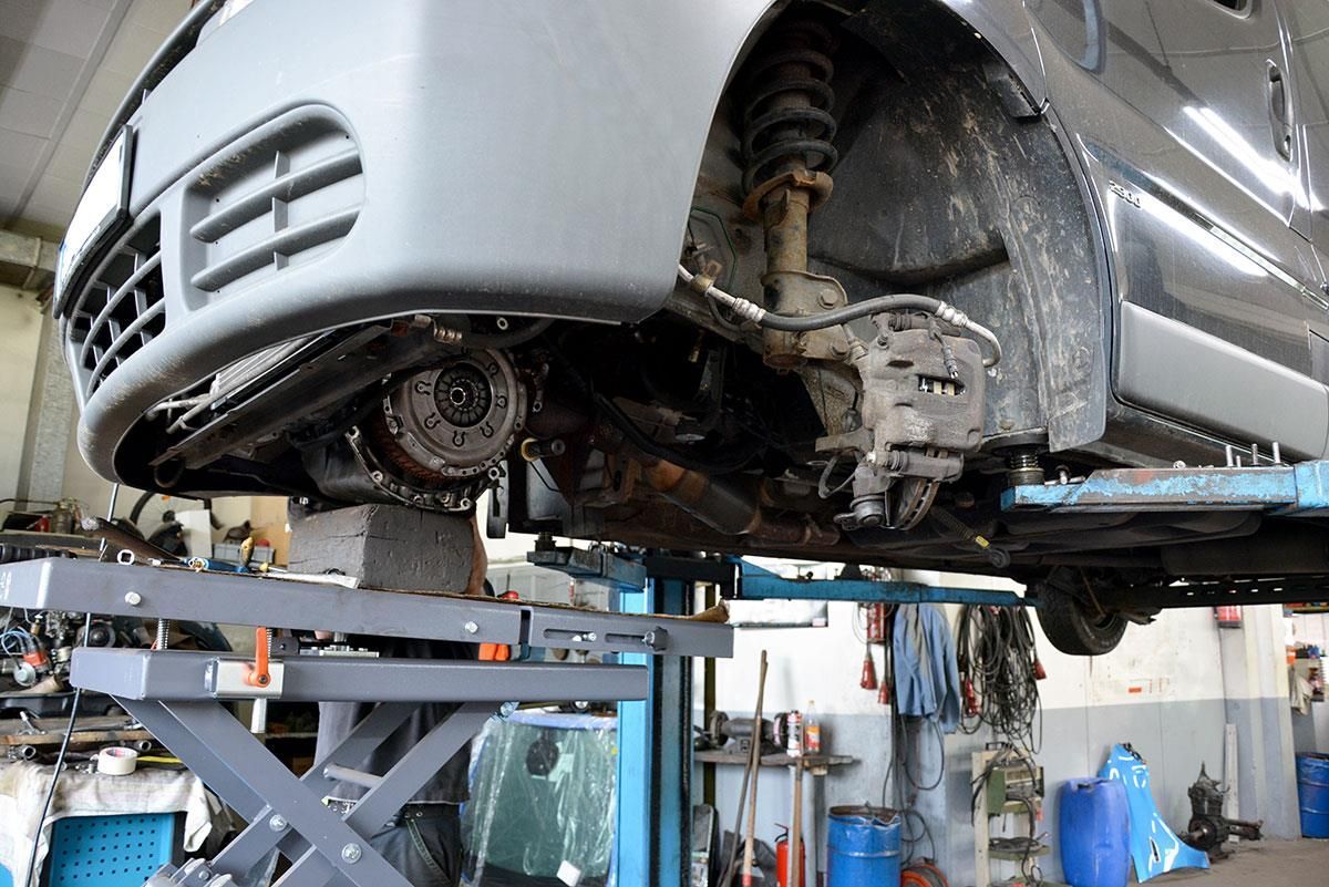 Ein Auto steht auf einer Hebebühne in einer Garage