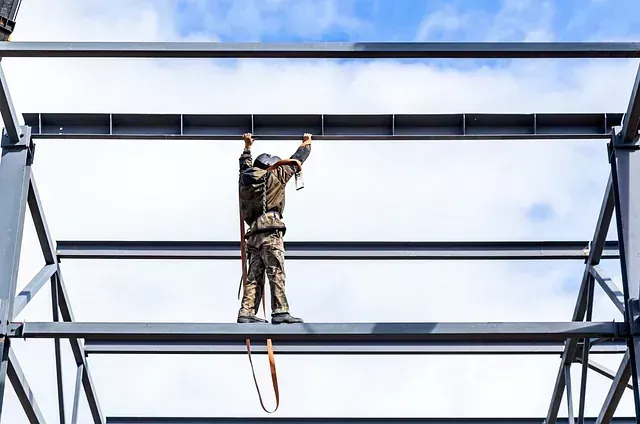 Un hombre está de pie encima de una estructura de metal.