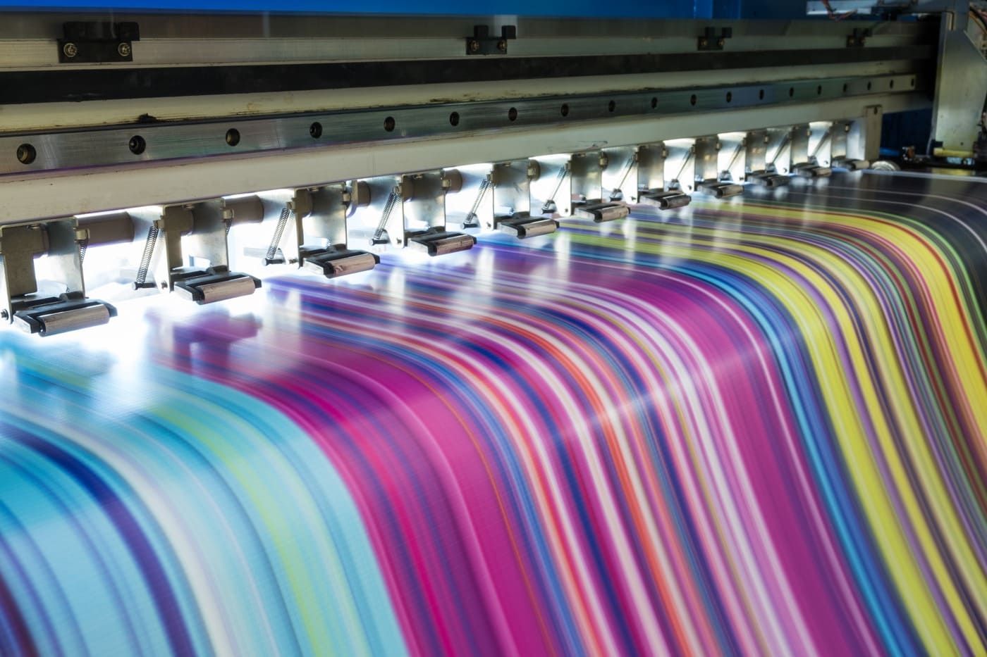 Se está imprimiendo una hoja grande de papel de colores en una impresora grande.