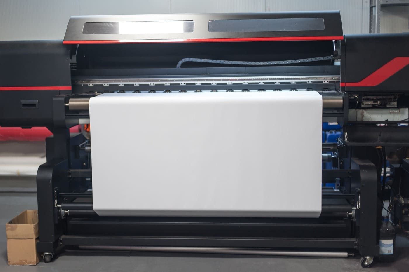Una impresora grande está imprimiendo una gran hoja de papel blanco.