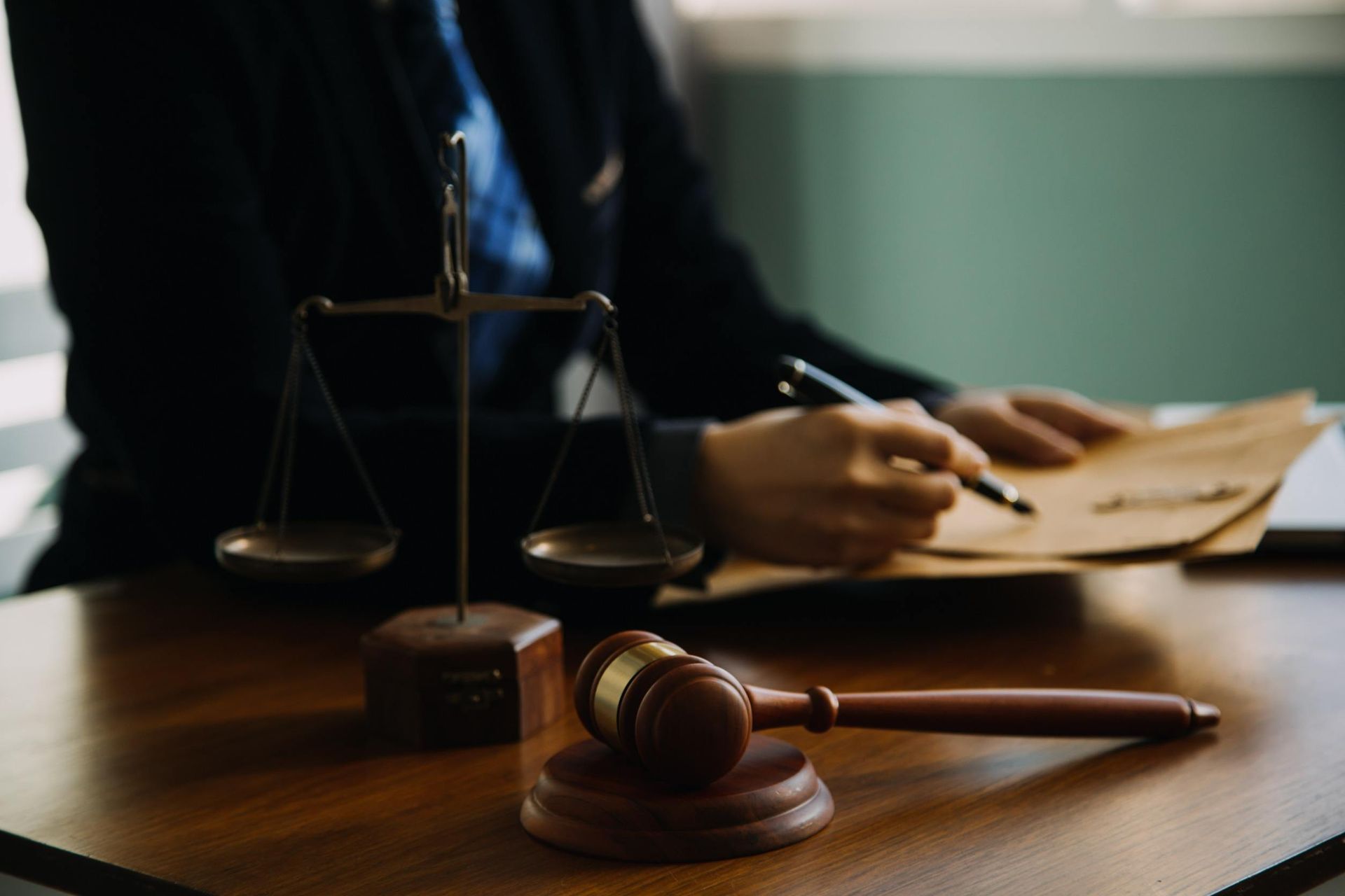 Un juez sentado en un escritorio con un mazo y una balanza de la justicia.