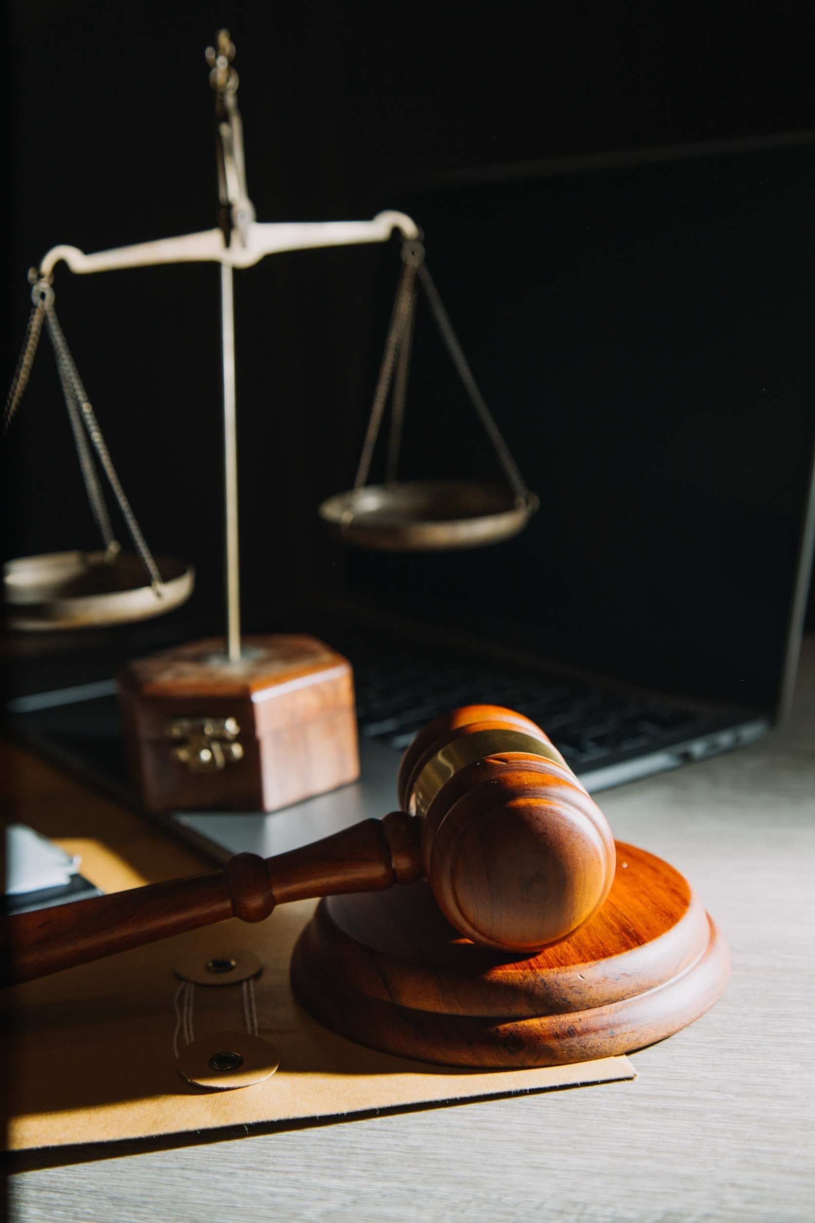 El mazo de un juez está sobre una mesa al lado de una balanza de justicia.