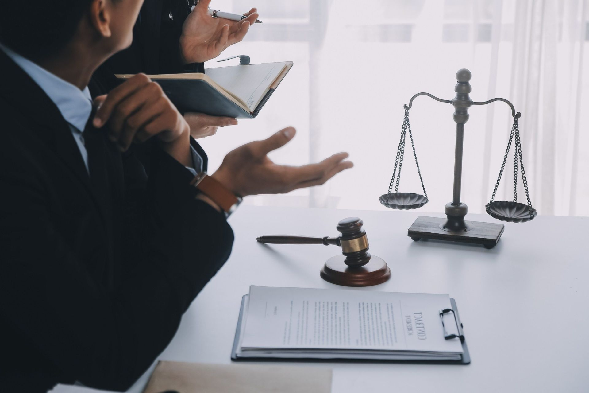 Un grupo de abogados está sentado en una mesa con una balanza de justicia y un mazo.