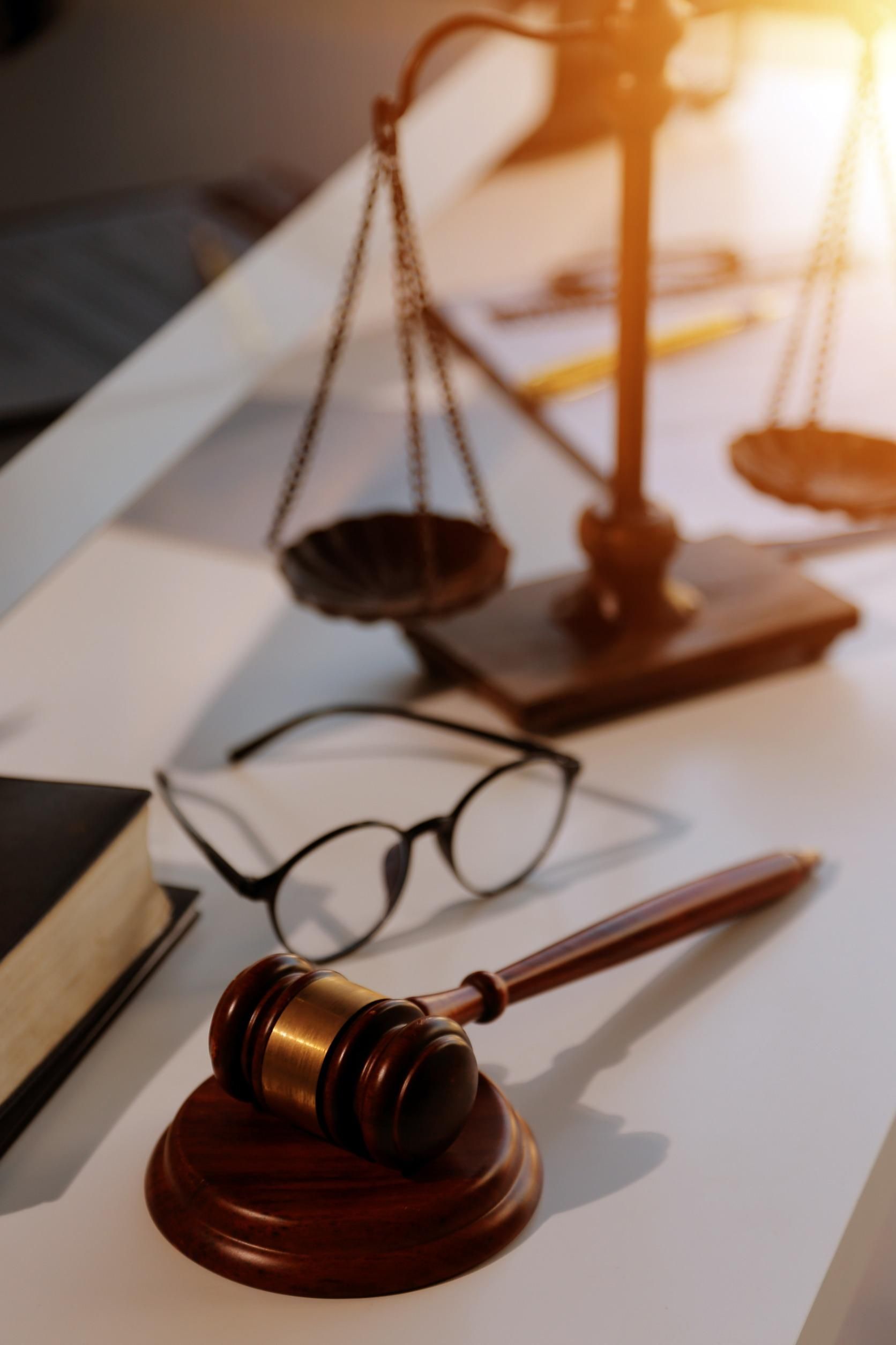 El mazo de un juez y la balanza de la justicia están sobre una mesa.