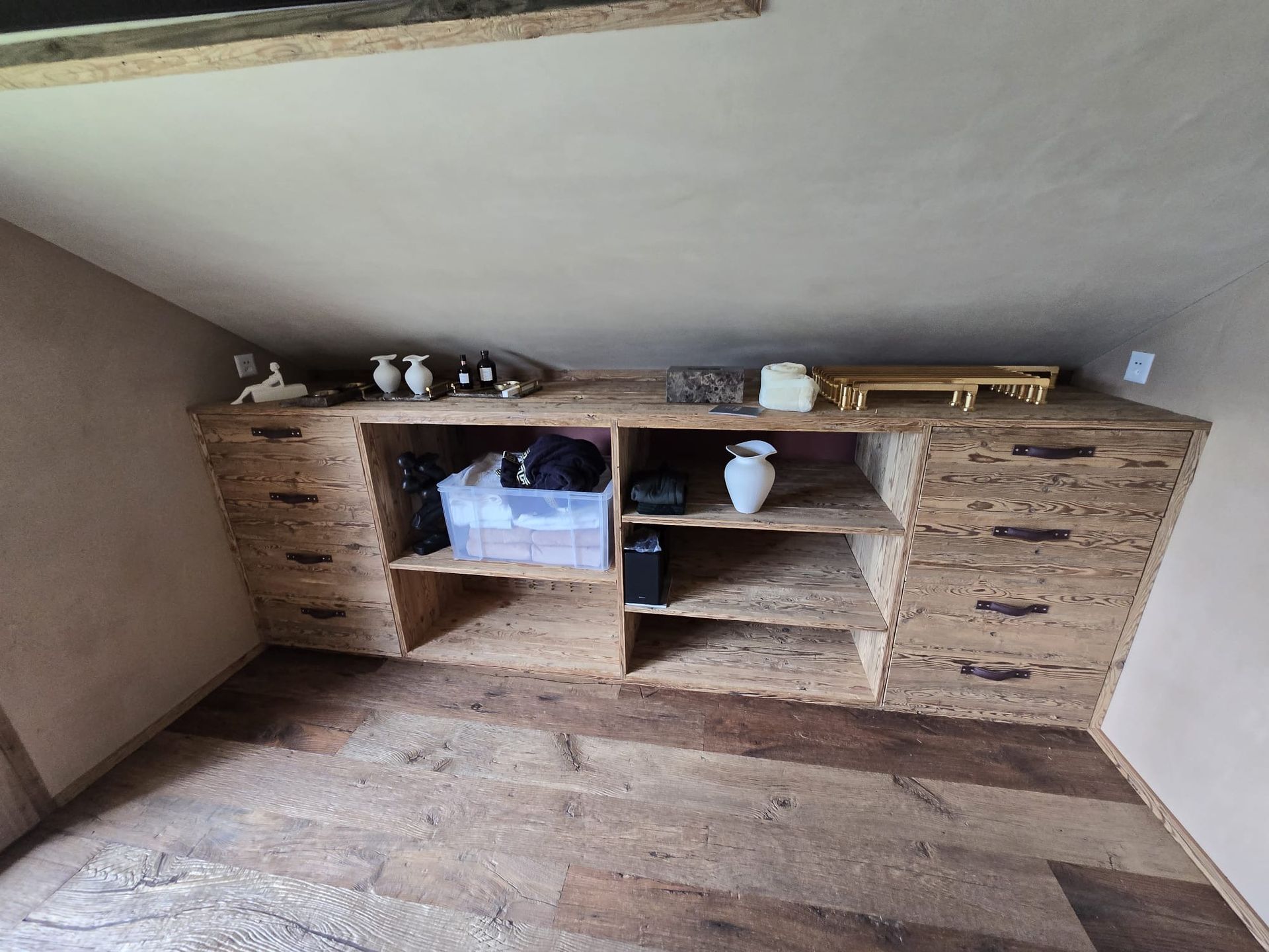 Hände messen Holz mit Bleistift und Lineal an einer vollgestellten Werkbank