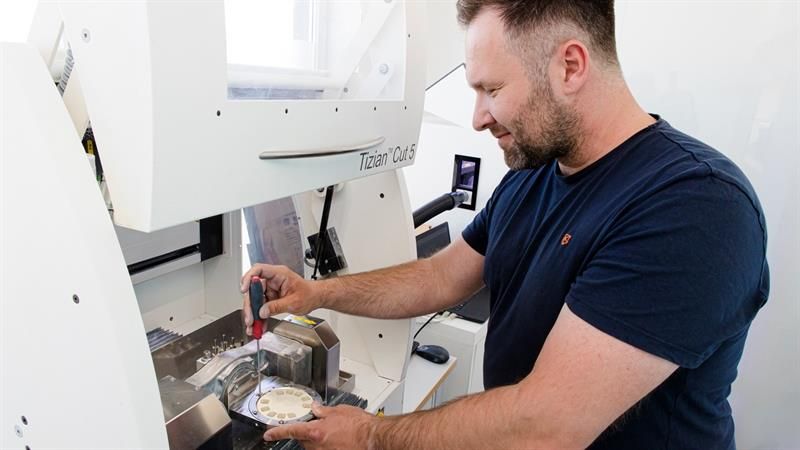 Ein Mann arbeitet in einer Fabrik an einer Maschine.