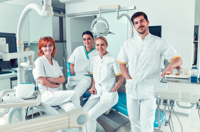 Un gruppo di dentisti posa per una foto in uno studio dentistico.