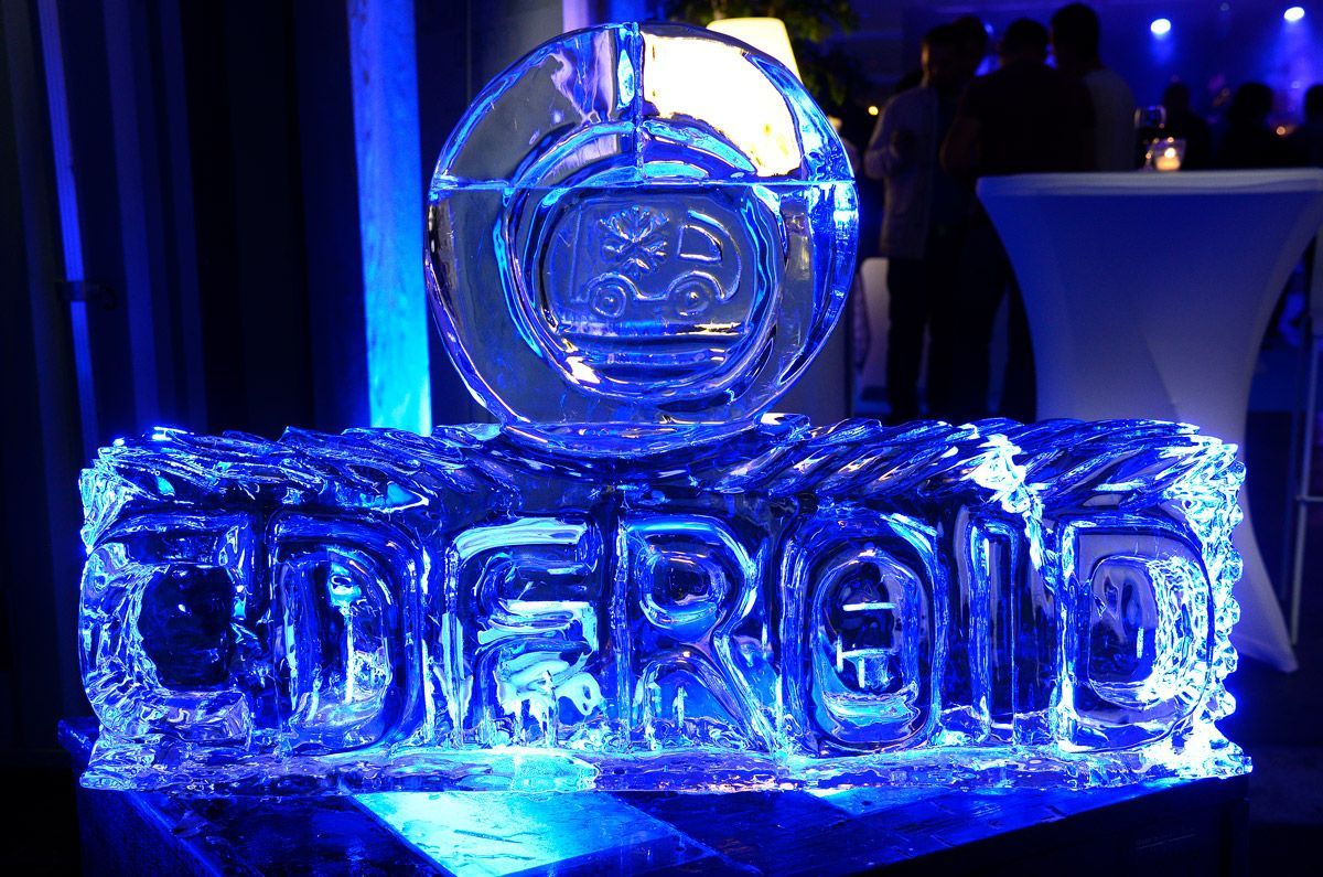 Une sculpture de glace bleue formant le mot CD FROID posée sur une table lors d'un événement