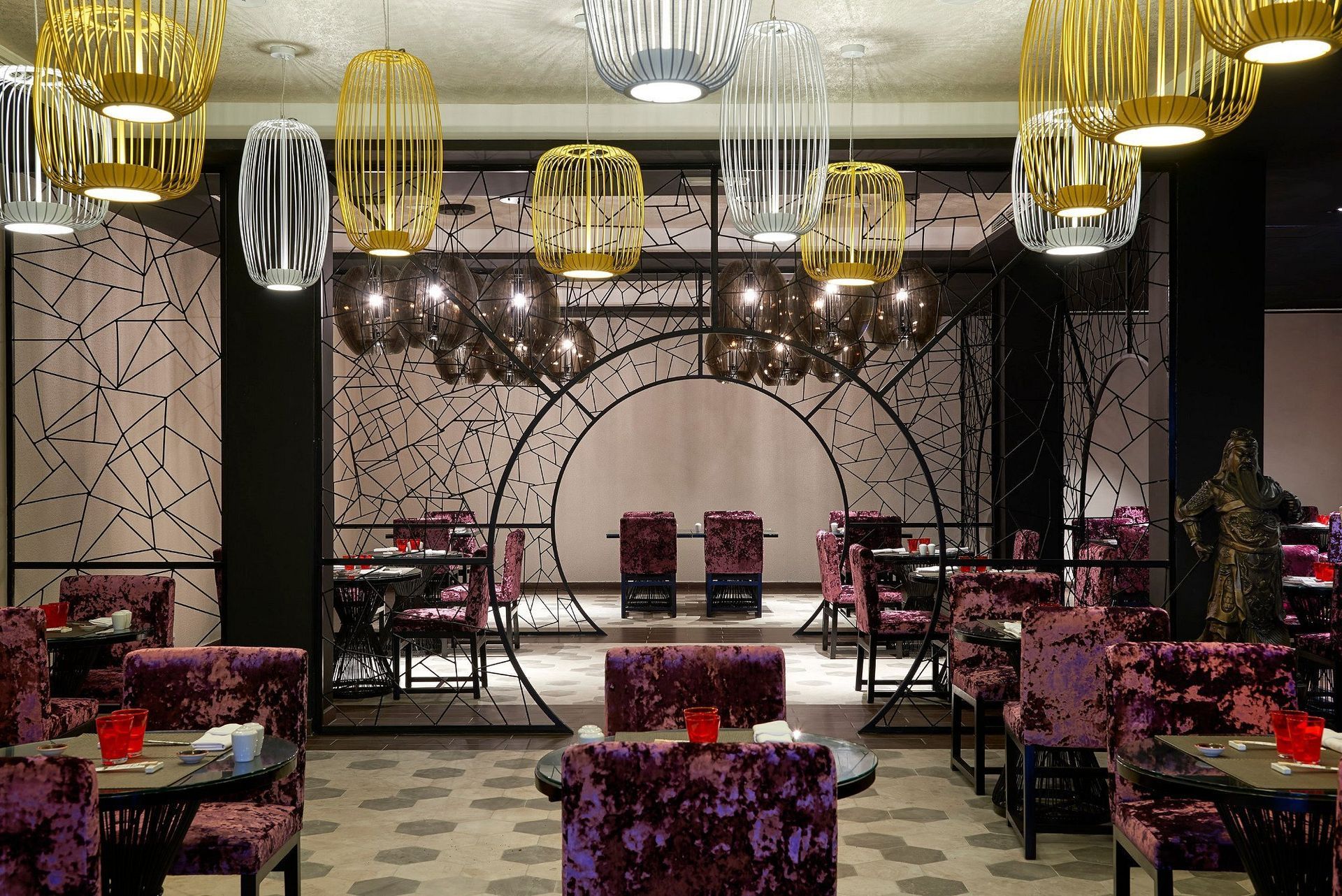 A restaurant with purple chairs and tables and a stage