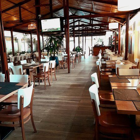 Um restaurante com mesas e cadeiras e piso de madeira