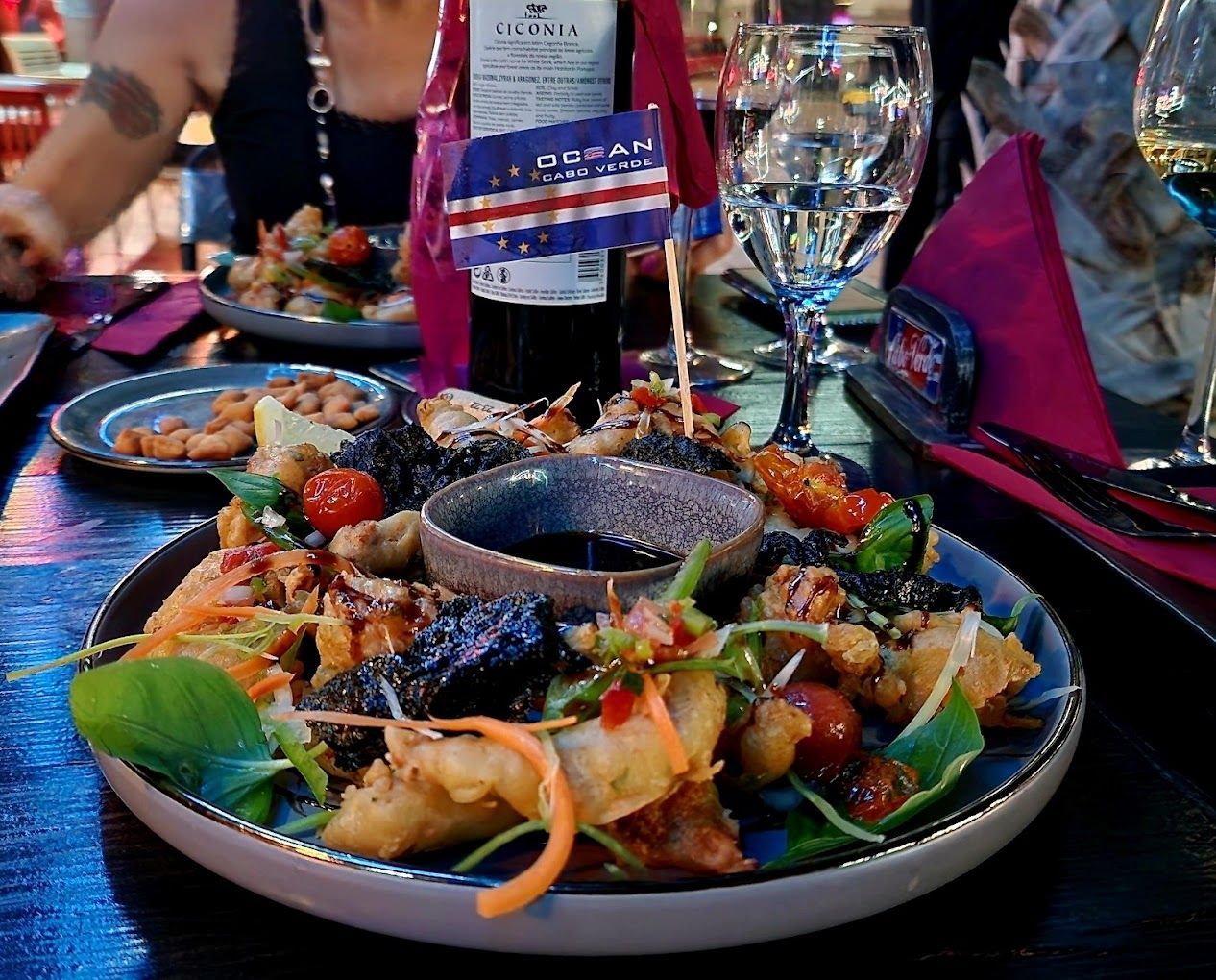 Um prato de comida e uma garrafa de vinho sobre uma mesa.