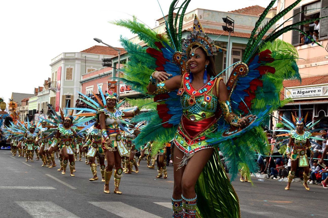 Uma mulher com uma fantasia colorida está dançando em um desfile