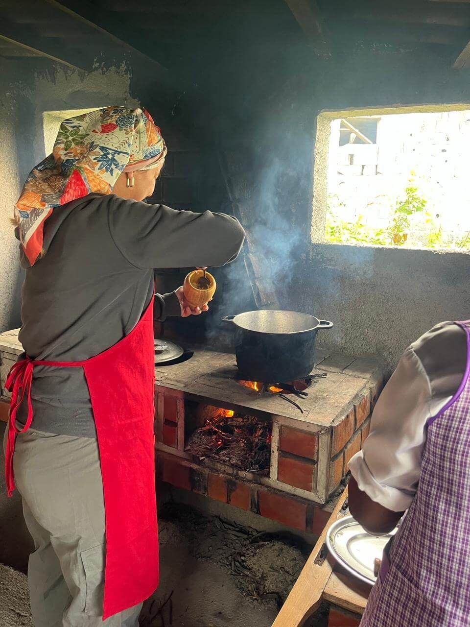 Tigela de ensopado com linguiça, carne, feijão, milho e batatas.