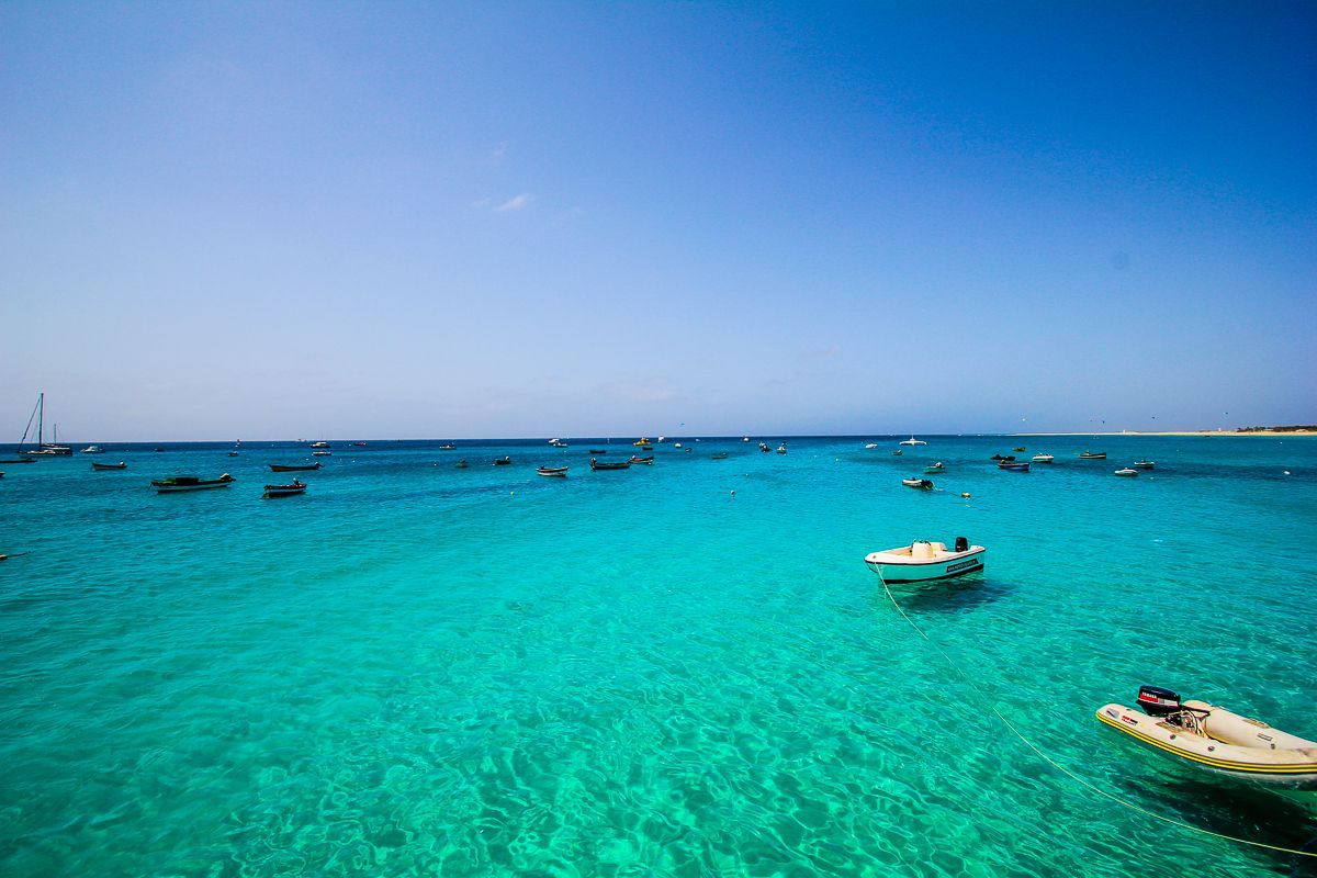 Um grupo de barcos flutua no topo de um oceano azul-turquesa.