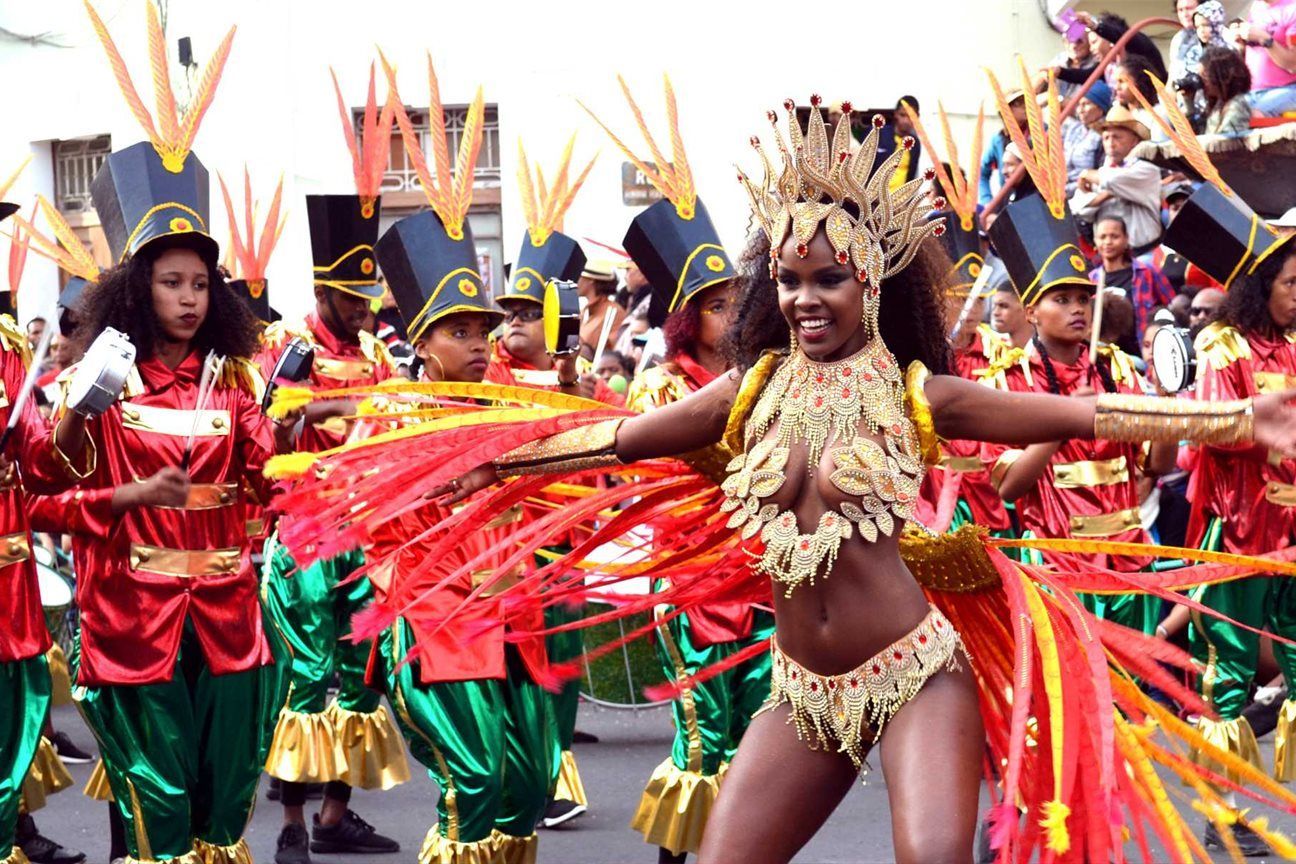 A woman in a colorful costume is dancing in a parade