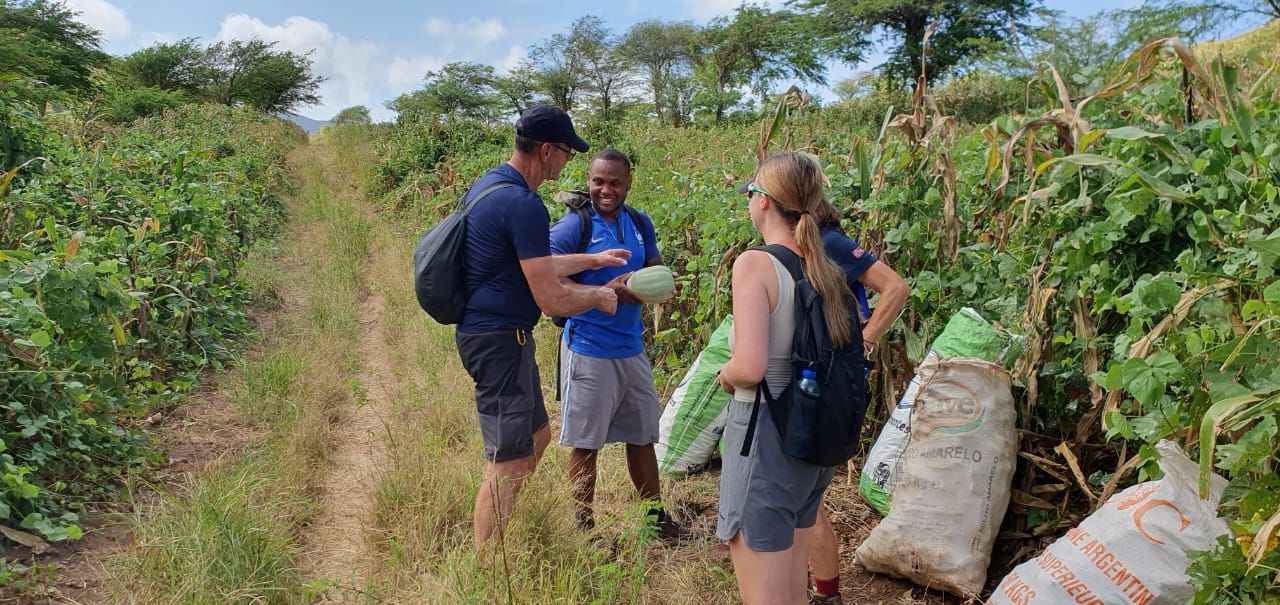 Um grupo de pessoas está em um campo conversando entre si.
