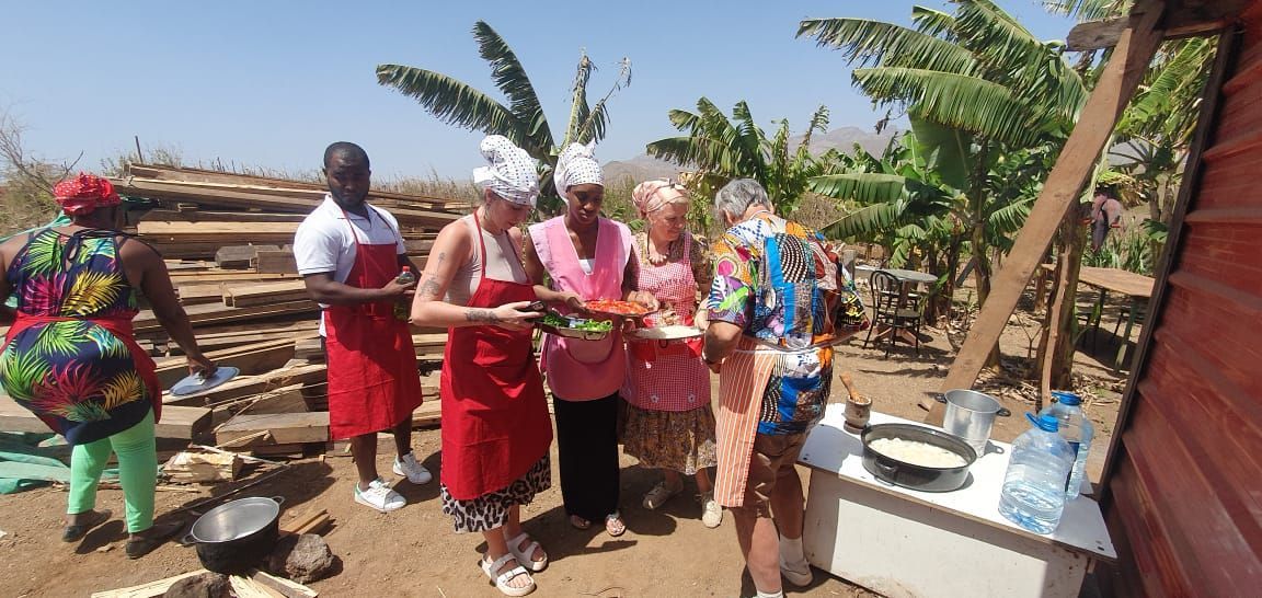 Um grupo de pessoas usando aventais e chapéus de chef está em volta de uma mesa.