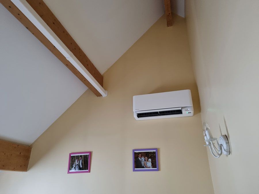 Pompe à chaleur positionnée sur le mur d’une chambre au-dessus de deux cadres