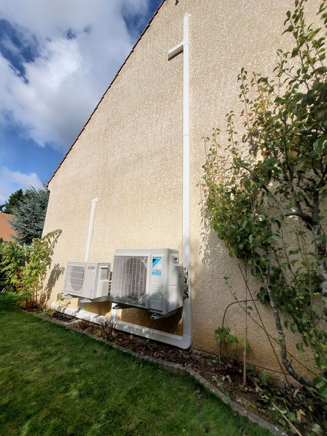 Deux pompes à chaleur devant du crépi