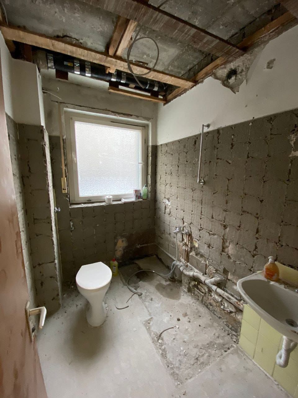 Badezimmer wird renoviert: Toilette, Fenster, Waschbecken, Sichtwände und Decke.