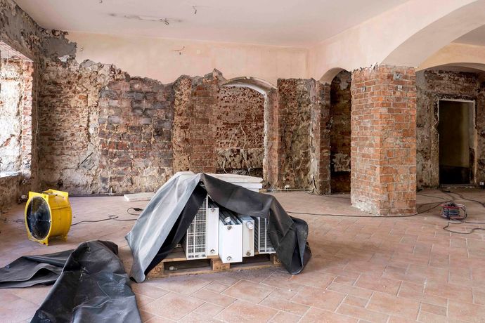 Ein leerer Raum mit Ziegelwänden und einem Ventilator