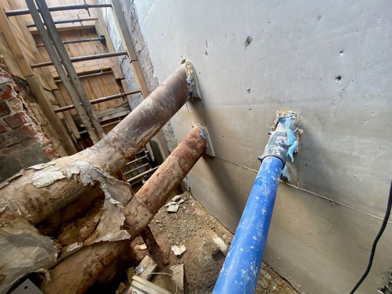 Ein blaues Rohr ragt aus einem Loch in einer Wand.