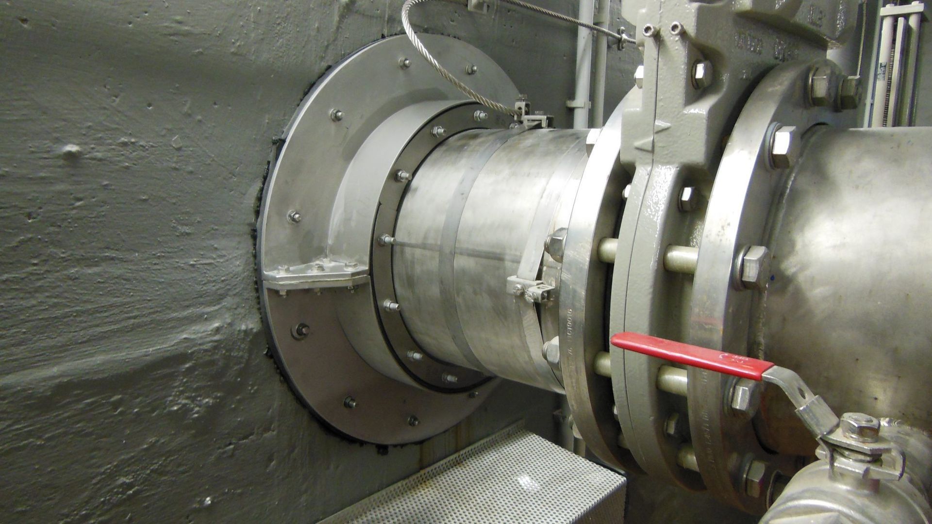 Ein Edelstahlrohr mit einem daran befestigten roten Ventil