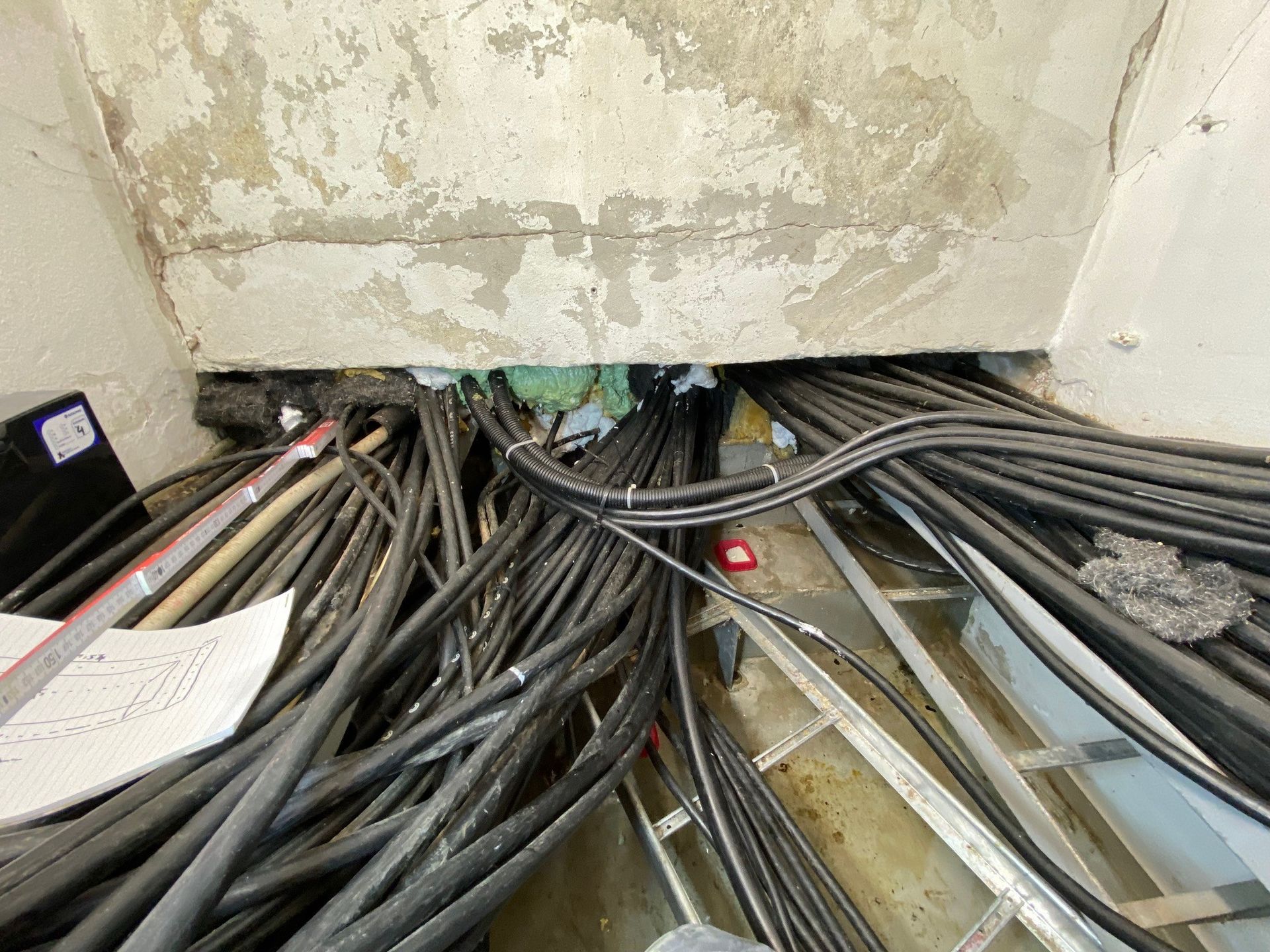 In einem Raum liegt ein Bündel Kabel auf dem Boden.