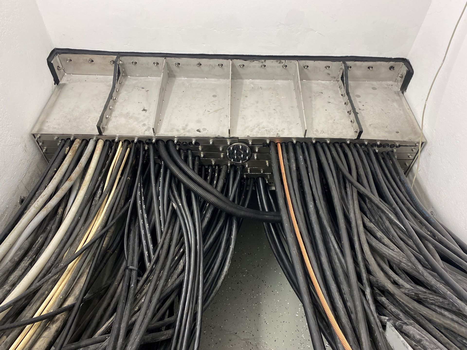 In einem Raum liegt ein Bündel Kabel auf dem Boden.