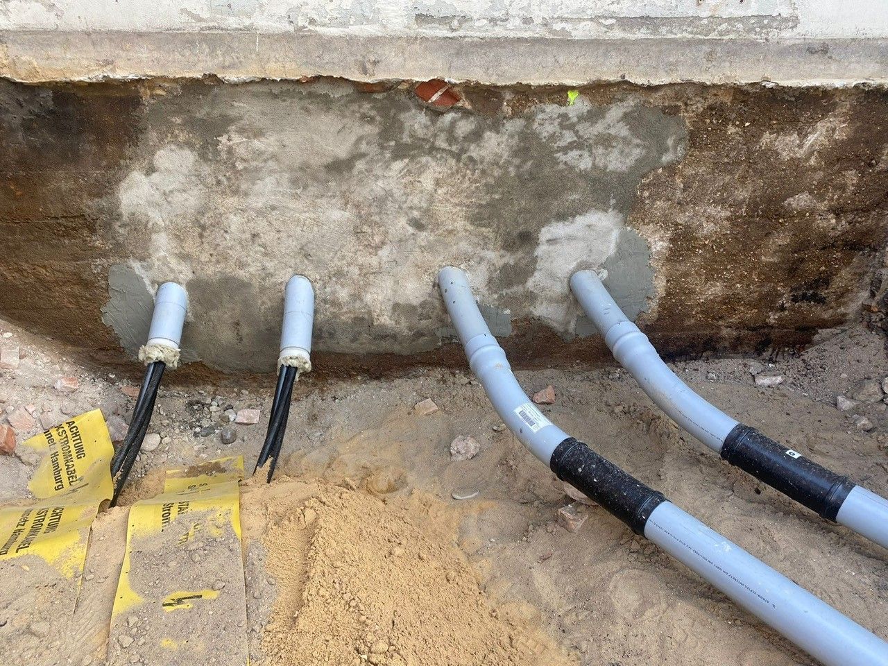 Ein Bündel Drähte kommt aus einem Loch im Boden.