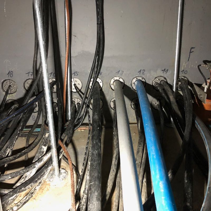 Ein Bündel Drähte hängen von einer Wand