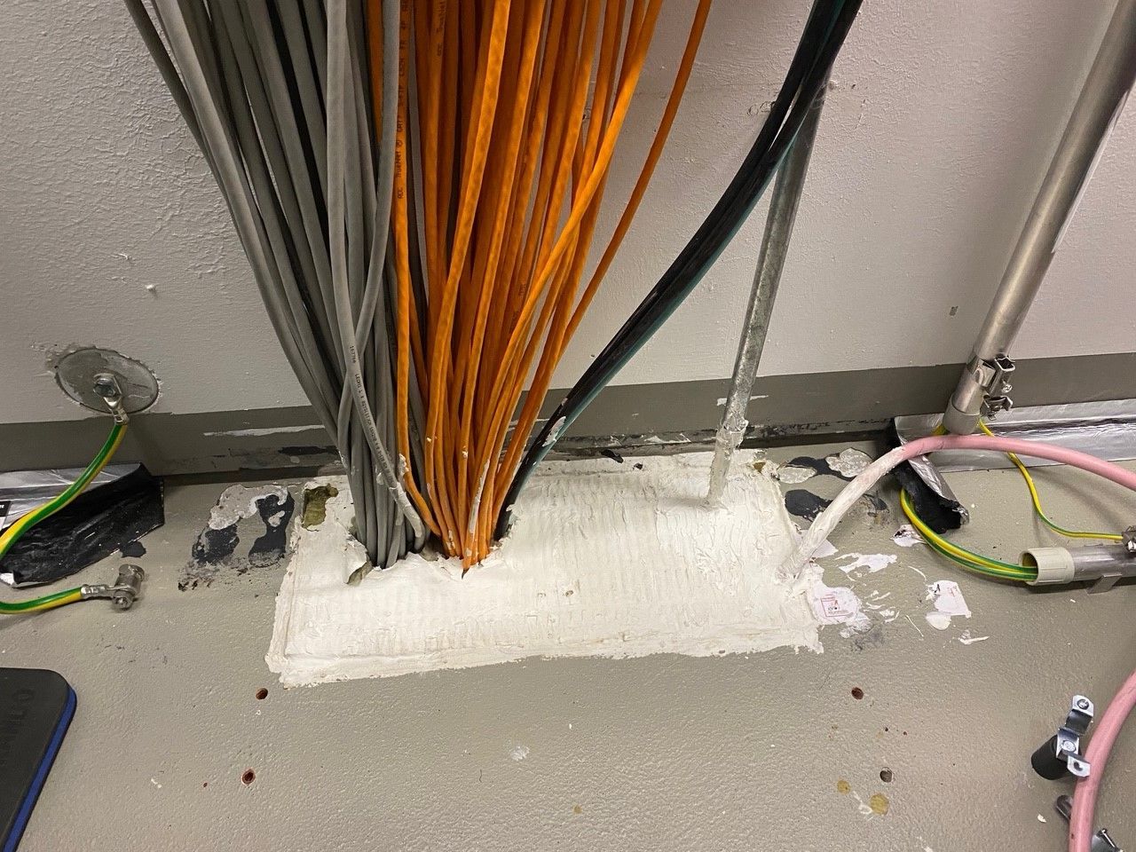 Aus einem Loch im Boden kommen viele Kabel heraus.