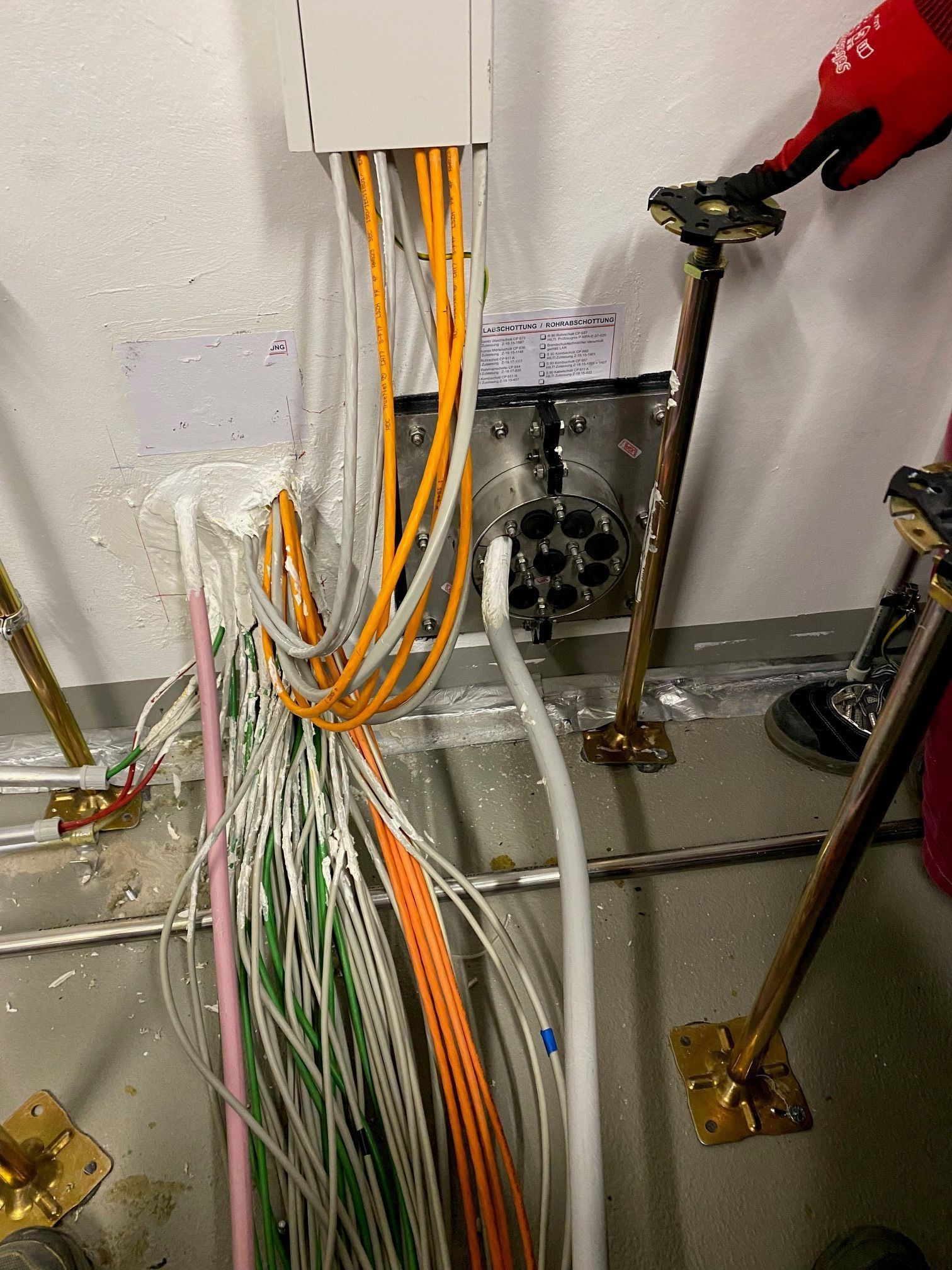 In einem Zimmer hängt ein Bündel Drähte von der Wand.