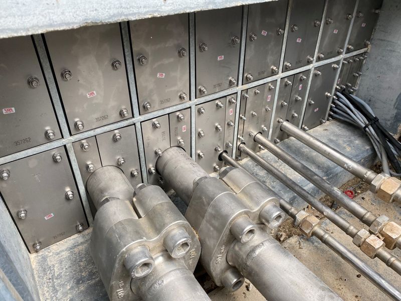 Mehrere Edelstahlrohre sind mit einer Wand verbunden.